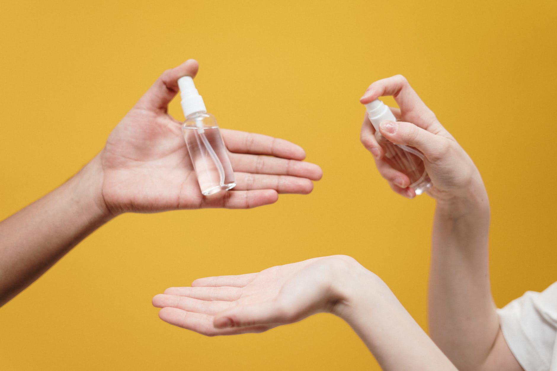 people holding clear glass bottle