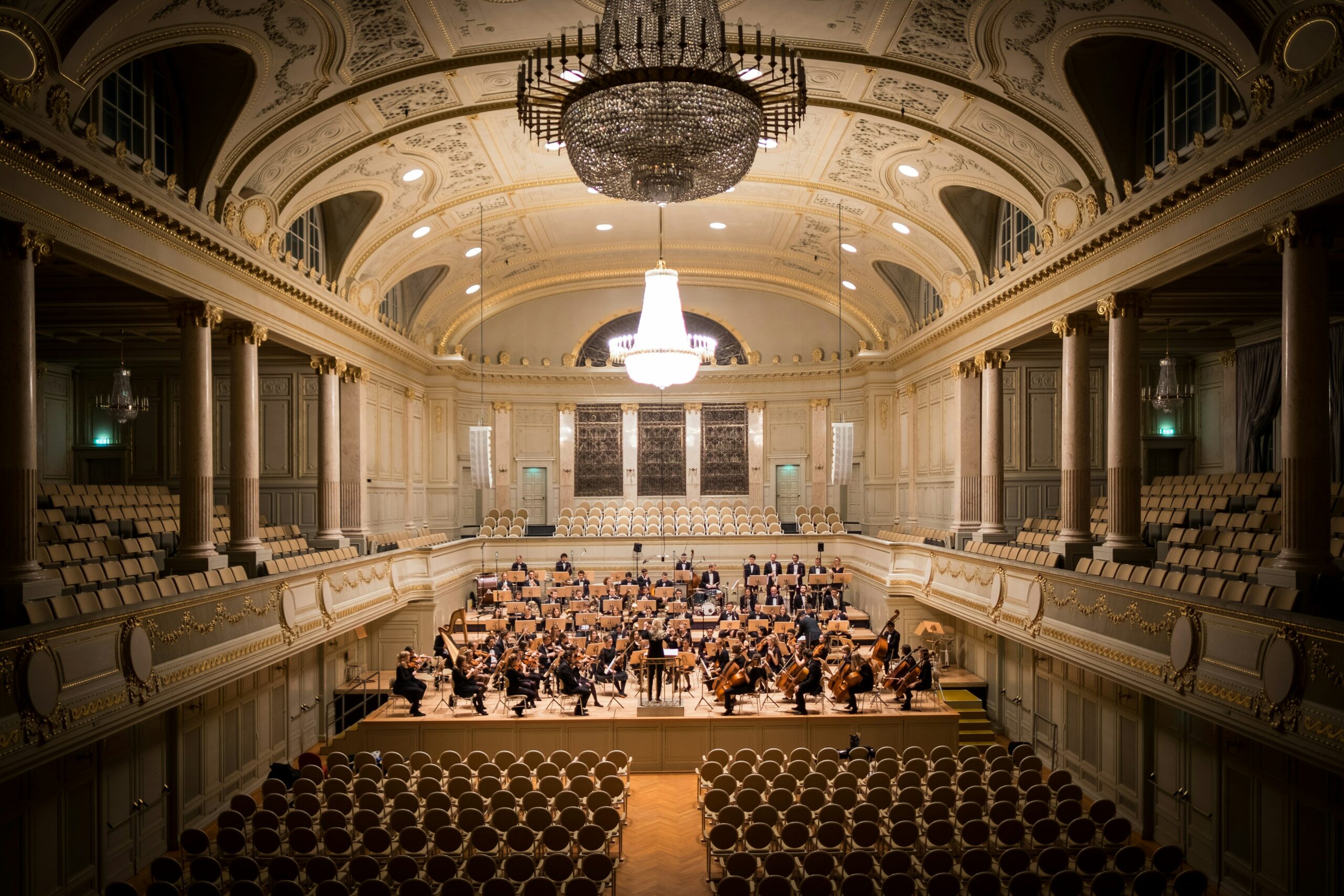 A picture of a music group in Switzerland performing on stage with empty audience seats