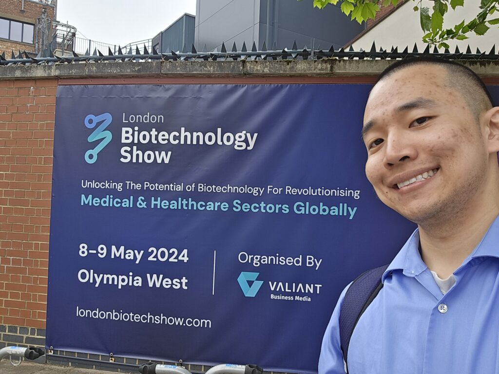 GenoWrite's Founder, Paul Naphtali, by a sign for the 2024 London Biotechnology Show in London, England.