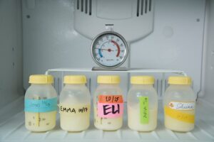 Breast milk stored in bottles inside a freezer