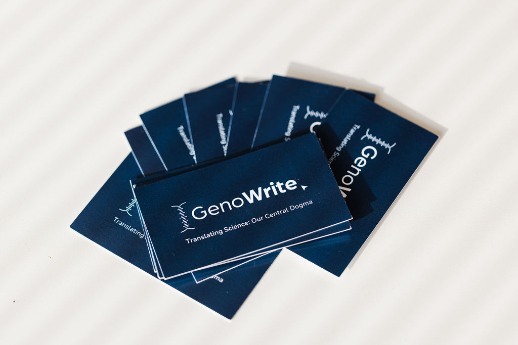 A pile of GenoWrite business cards arranged on a desk