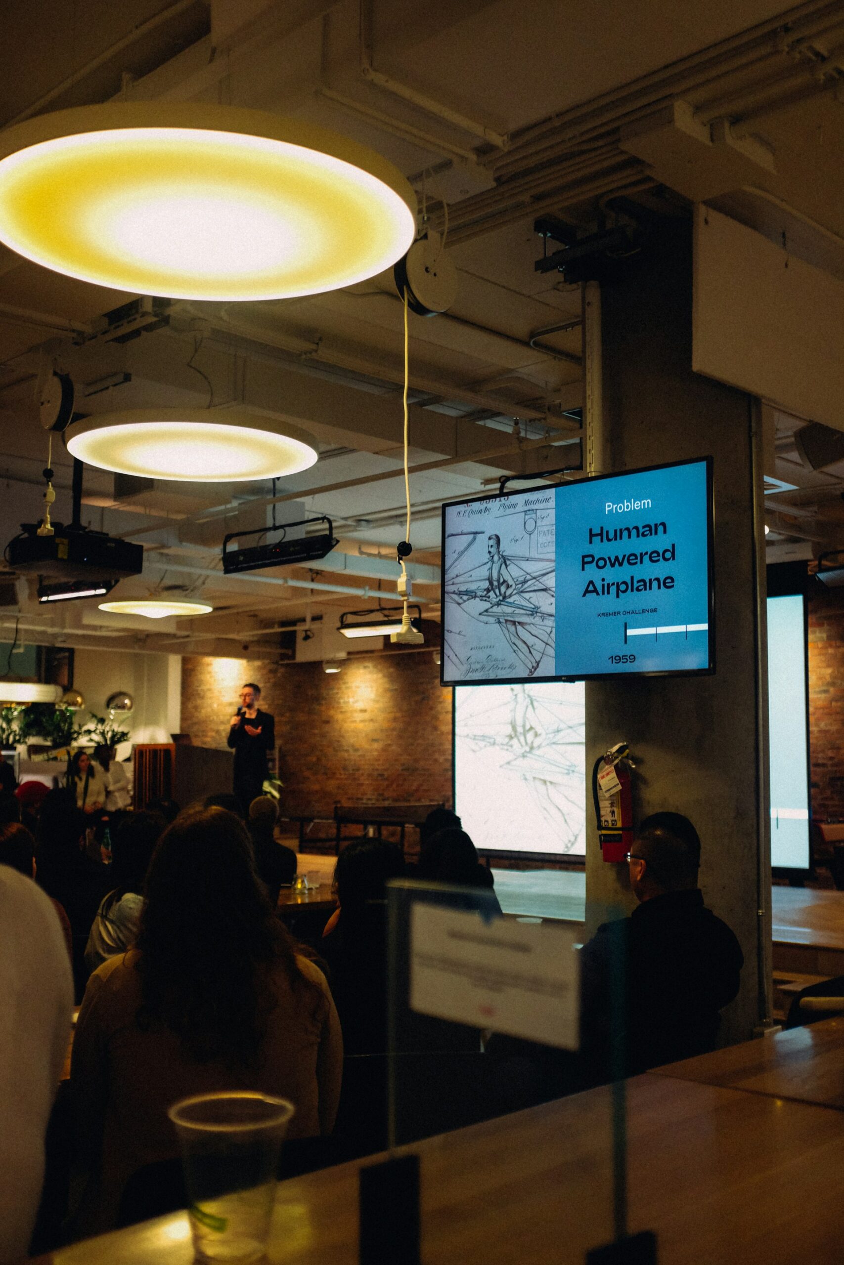 A person giving a PowerPoint presentation to a small audience.